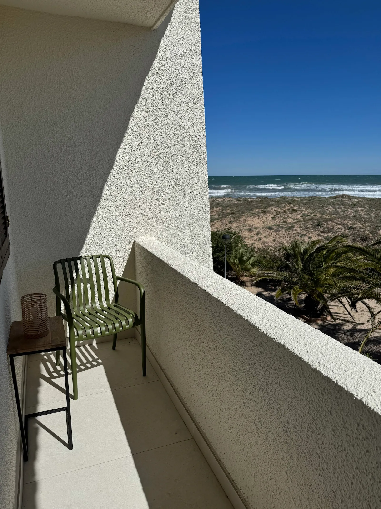 Terraza con silla y vistas al mar y dunas